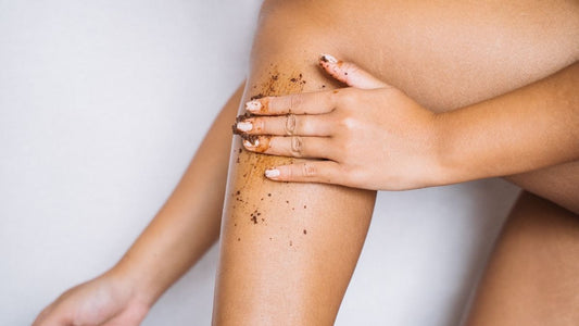 Woman gently applying natural body scrub to her lower leg to exfoliate and smooth dry, rough skin.