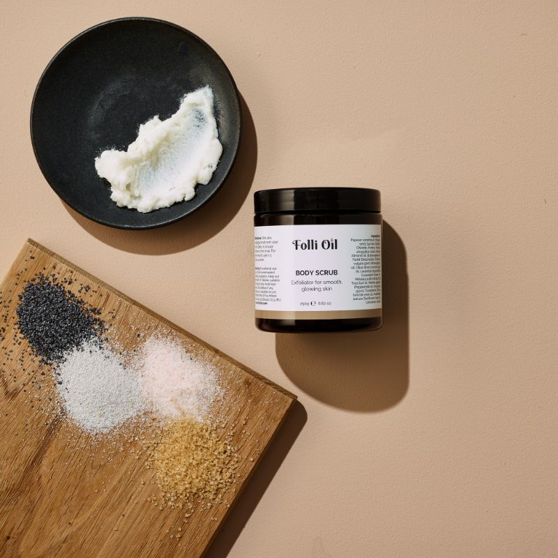 Flat lay of open Body Scrub jar surrounded by raw ingredients – showcasing natural exfoliating power.