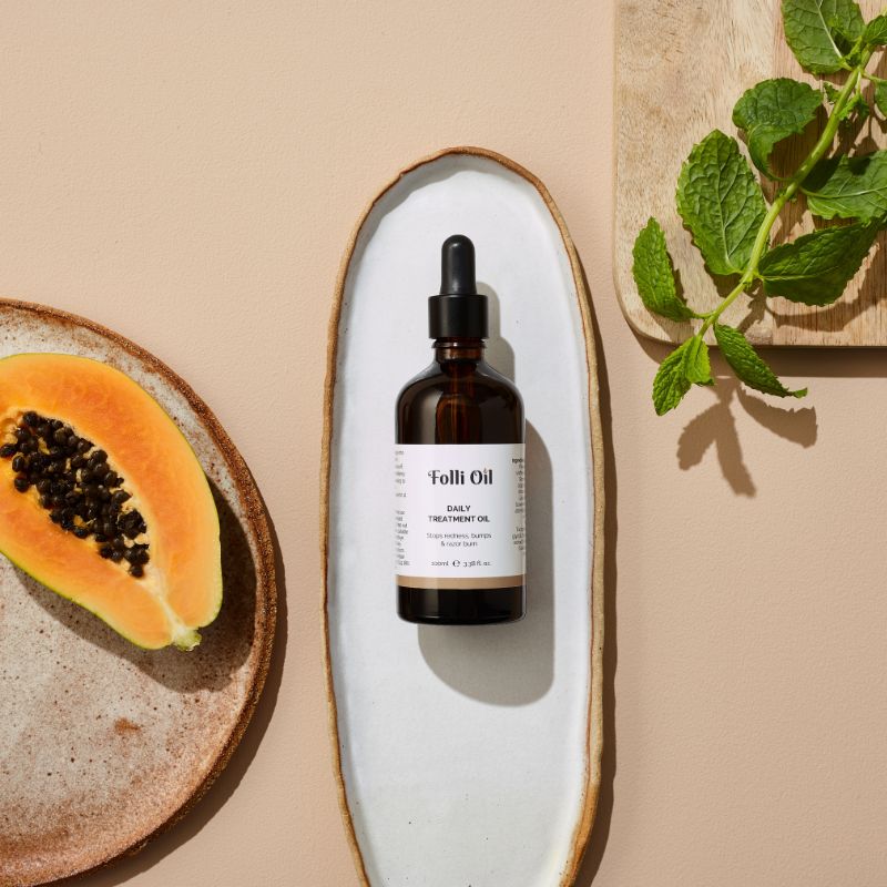 Flat lay of Folli Oil Daily Treatment Oil bottle on neutral background – showcasing clean, natural skincare.