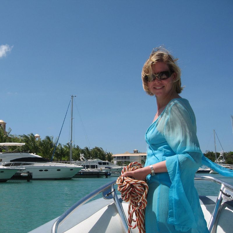 Folli Oil founder in swimwear on a boat in Barbados – confident, glowing skin in the sunshine.